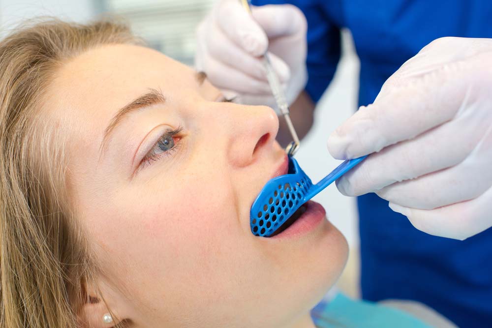 woman getting dental impression for orthodontist sports mouthguard